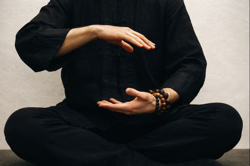 Person in meditation pose with prayer beads