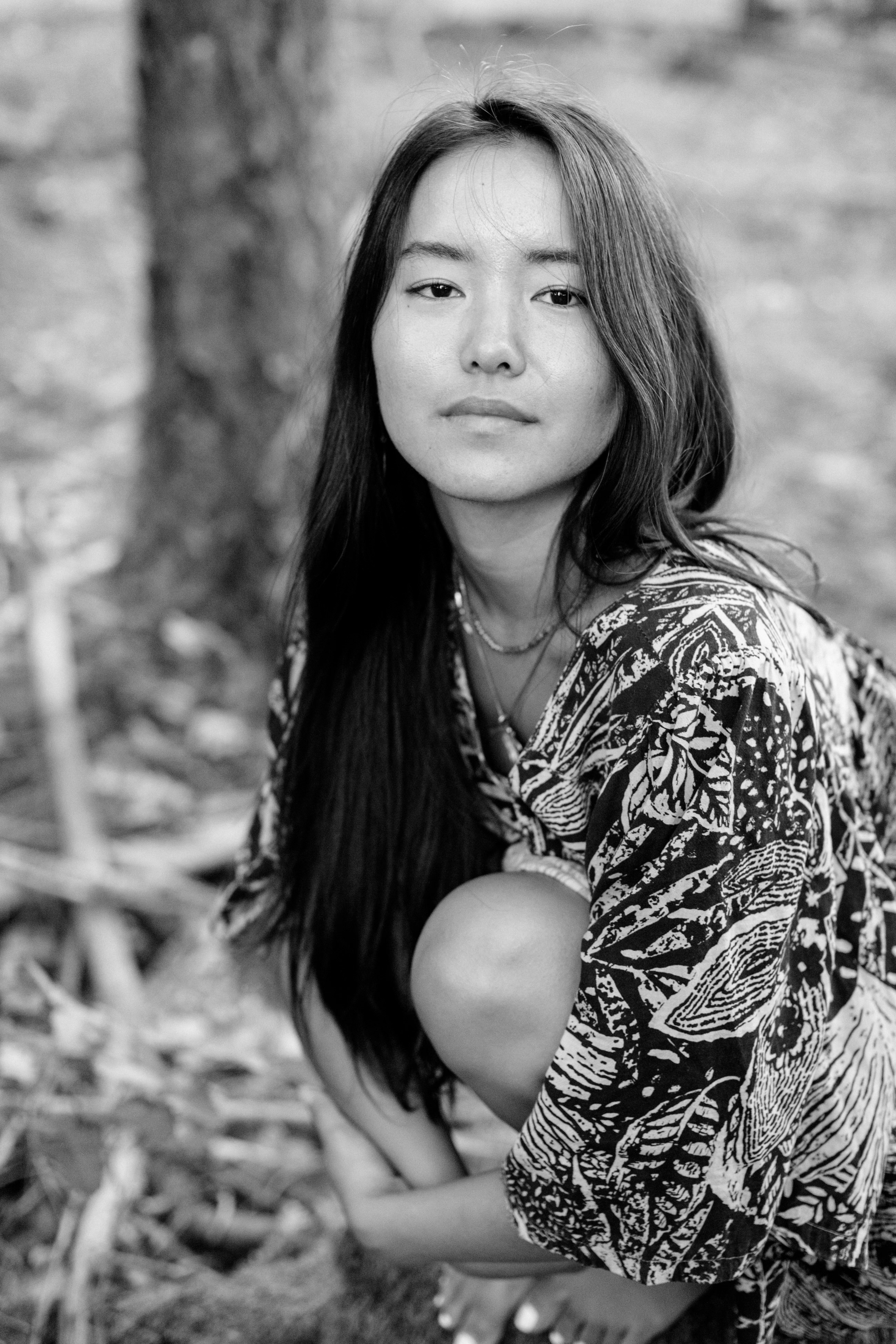 Black-and-white portrait of Sophia seated in a forest